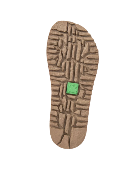 Suela beige con dibujo de tacos y pieza verde en el centro.