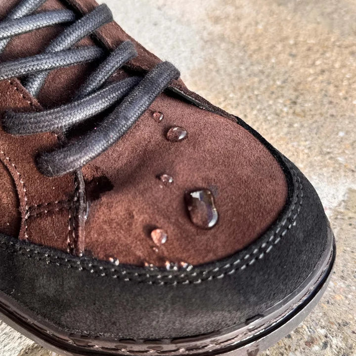 Detail of the brown suede vamp with water droplets and dark laces.