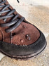 Detail of the brown suede vamp with water droplets and dark laces.