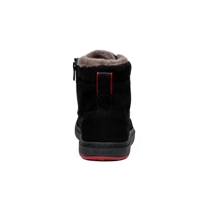 Rear view of the black ankle boot, with a red strap and gray sole.