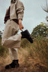 Person wearing black ankle boots on a grassy path, viewed from the side.